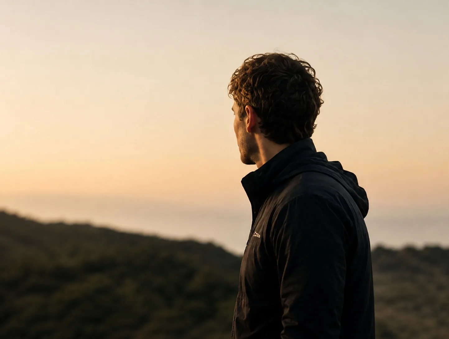 A person watching the horizon in soft evening light
